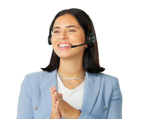 A woman wearing a light blue blazer and a headset smiles and clasps her hands together, appearing friendly and engaged, as if speaking with a customer or client.